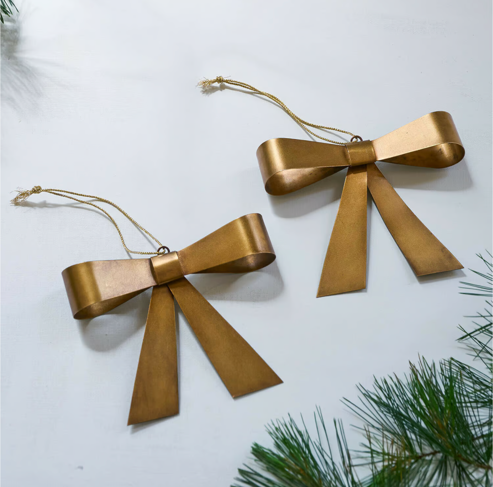 Two gold-toned Helavine bow ornaments